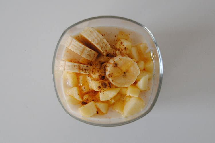 Cups of yogurt, banana, apple and honey